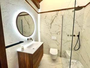 een badkamer met een wastafel en een douche met een spiegel bij Apartamento Rustic Chic 28C in El Tarter