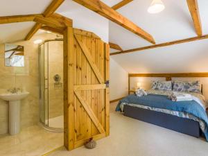 um quarto com uma cama e uma porta de correr no celeiro em 3 Bed in Chulmleigh 87779 em Eggesford