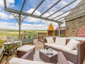 a patio with a couch and chairs on a deck at 2 Bed in Kielder 88214 in Yarrow