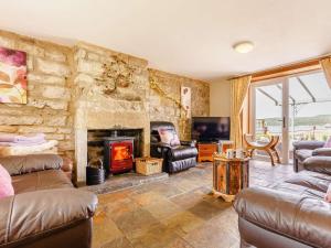 a living room with a stone wall with a fireplace at 2 Bed in Kielder 88214 in Yarrow