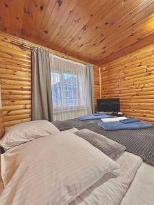 a bedroom with two beds in a wooden room at Carpathian manor in Yaremche