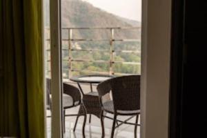 mit Blick auf einen Balkon mit einem Tisch und Stühlen in der Unterkunft Aaravam Ganga Boutique Hotel , Rishikesh in Rishikesh