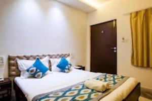 ein Schlafzimmer mit einem großen Bett mit blauen Kissen in der Unterkunft Aaravam Ganga Boutique Hotel , Rishikesh in Rishikesh