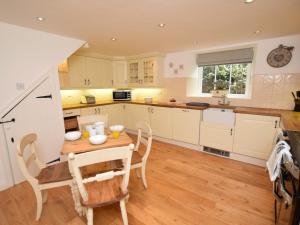 a kitchen with white cabinets and a table and chairs at 3 bed in Bamburgh 87918 in Bamburgh