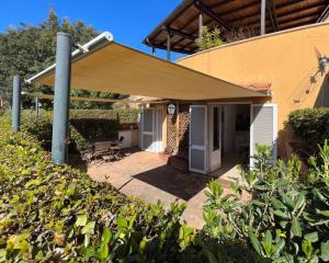 un patio con toldo bronceado en una casa en Suite del Mascherino, en Monte Argentario