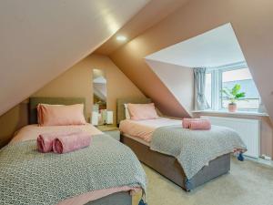 a attic bedroom with two beds and a window at 3 Bed in Lossiemouth 87871 in Lossiemouth