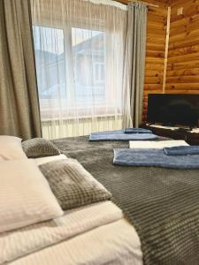 a bedroom with two beds and a large window at Carpathian manor in Yaremche