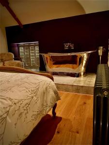 ein Schlafzimmer mit einem Bett und einer Badewanne in einem Zimmer in der Unterkunft The Cottage, Everards Farm in Chewton Mendip