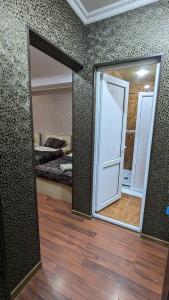 Habitación con espejo y dormitorio con cama. en Dkd-bridge Hotel, en Tiflis