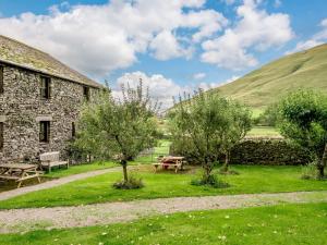 a stone building with a picnic table and trees at 1 Bed in Mosedale 88201 in Mosedale