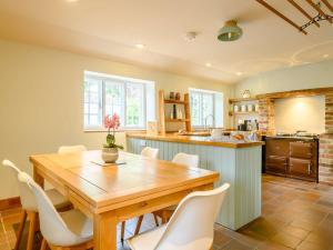 cocina con mesa de madera y sillas blancas en 3 Bed in Beaminster 87914 en South Perrott