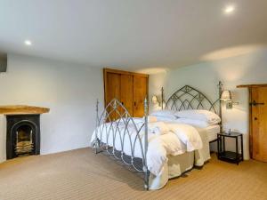1 dormitorio con 2 camas y chimenea en 3 Bed in Beaminster 87914 en South Perrott