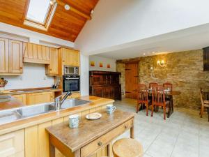 a kitchen with wooden cabinets and a dining room with a table at 2 Bed in Hexham 88443 in Acomb
