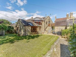 an exterior view of a large stone house with a yard at 2 Bed in Hexham 88443 in Acomb