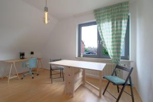 een kamer met een tafel en stoelen en een raam bij Js53-og in Bremerhaven