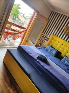 a blue bed with a yellow headboard in a bedroom at Casa tranquila parece interior bem localizada. in Osasco