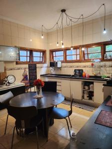 uma cozinha com uma mesa e cadeiras numa cozinha em Casa tranquila parece interior bem localizada. em Osasco