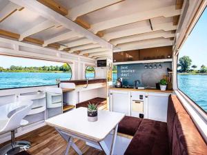a kitchen and a table in the middle of a boat at Attractive houseboat in Kinrooi with terrace in Kinrooi