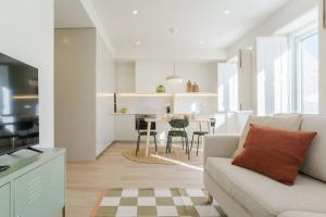 a white living room with a couch and a table at Modern & Bright Faro Mercado Apt 12 in Faro