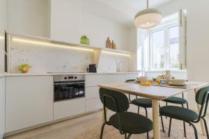 a kitchen with a table and chairs in a kitchen at Modern & Bright Faro Mercado Apt 12 in Faro