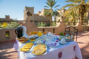 uma mesa com comida em frente a um edifício em Ksar Elkabbaba Kasbah & SPA em Skoura