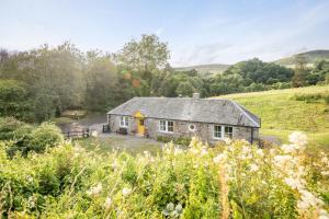 a stone house in the middle of a field at Burnside - gorgeous romantic cottage for 2 in Monzie