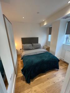 1 dormitorio con 1 cama con manta verde en Trendy apartment in Croydon central en Croydon