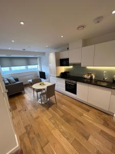 a kitchen and living room with a table and a couch at Trendy apartment in Croydon central in Croydon