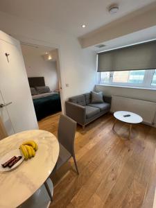 una sala de estar con una mesa con plátanos. en Trendy apartment in Croydon central en Croydon