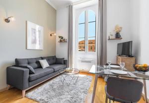 a living room with a couch and a glass table at MY CASA - DELOYE - GUSTAVE - Spacious and Quiet studio with Ac near Old Town in Nice