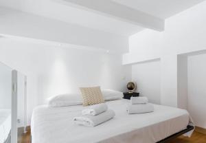 a white bedroom with a large bed with towels on it at MY CASA - DELOYE - GUSTAVE - Spacious and Quiet studio with Ac near Old Town in Nice