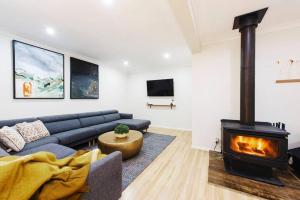 a living room with a couch and a fireplace at The Orange Door Mudgee -a spacious home in town in Mudgee