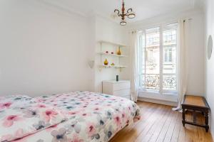 a white bedroom with a bed and a window at Le Marais, fantastic view on Archives Nationales in Paris