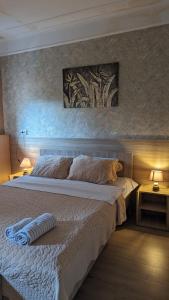 1 dormitorio con 1 cama grande y una pintura en la pared en Dkd-bridge Hotel, en Tiflis