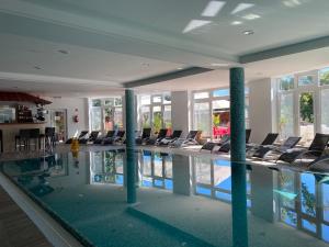 una piscina con sillas en un edificio en Sástó Hotel en Matrafured