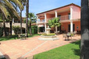 a house with a courtyard with a fountain and chairs at GRILEG- Pour des vacances idéales en famille ! T2 cabine dans résidence avec piscine chauffée in Grimaud