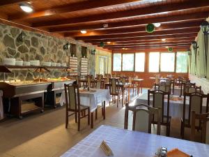 a restaurant with tables and chairs and a buffet at Sástó Hotel in Matrafured