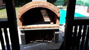 un horno de pizza de ladrillo sentado junto a una piscina en Villa Ruzmarin, en Zolaći