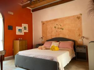 ein Schlafzimmer mit einem großen Bett mit orangefarbenen Wänden in der Unterkunft Hotel Villa Belfiori in Torre Dei Corsari