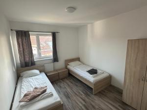Habitación pequeña con 2 camas y ventana en city apartment, en Graz