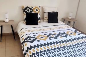 a bedroom with a black and white bed with pillows at Les lataniers 2 - Vue sur mer in Saint-Pierre