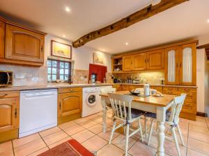 a kitchen with wooden cabinets and a table and chairs at 3 Bed in Buttermere 88773 in Buttermere