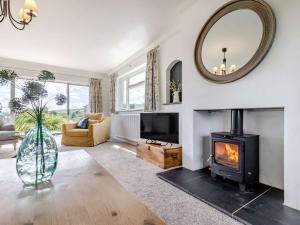 a living room with a fireplace and a mirror at 3 Bed in Ashford In The Water 88675 in Great Longstone