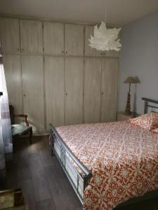 Schlafzimmer mit einem Bett und einem Kronleuchter in der Unterkunft "Côté nature", appartement cosy au cœur de Munster in Munster