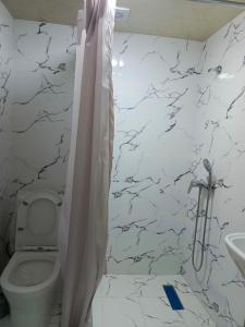 a white bathroom with a toilet and a sink at ADORA HOSTEl in Tashkent