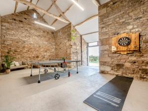 a ping pong table in a room with a stone wall at 5 Bed in Bassenthwaite 89496 in Torpenhow