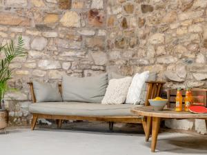 a bench with pillows on it in front of a stone wall at 5 Bed in Bassenthwaite 89496 in Torpenhow