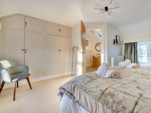 a bedroom with a large bed and a chair at 5 Bed in Bassenthwaite 89496 in Torpenhow