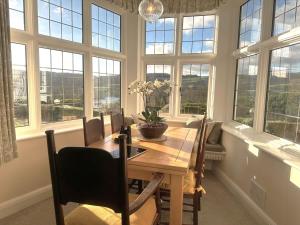 a dining room with a wooden table and windows at 3 Bed in Hawkshead 88985 in Near Sawrey