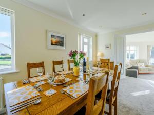 a dining room with a wooden table and chairs at 4 Bed in Braunton 89603 in Braunton